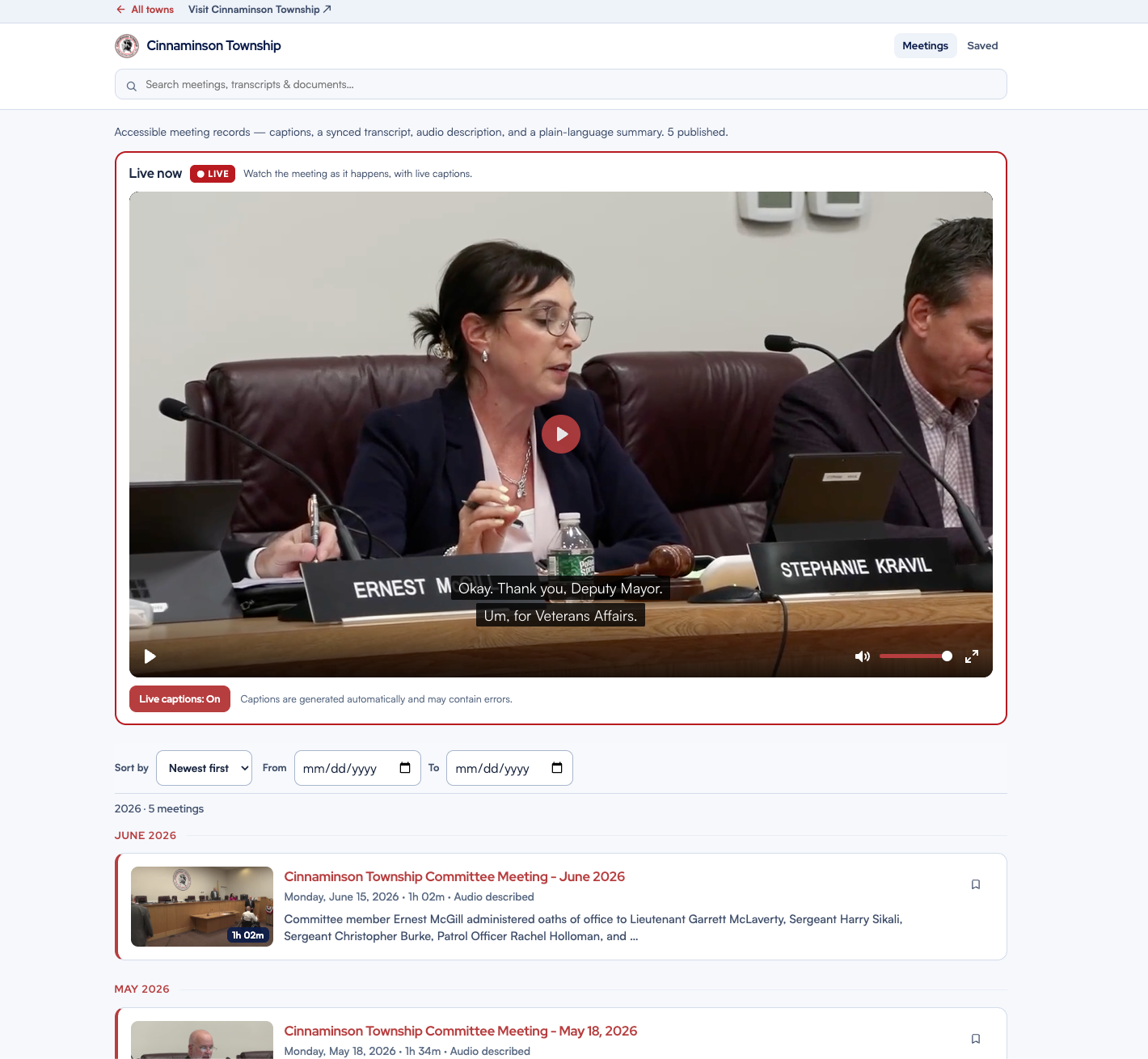 A town resident portal streaming a township committee meeting live — a red LIVE badge, a council member speaking at the dais, and live captions on screen reading the current sentence, above the town’s list of accessible meeting recordings.